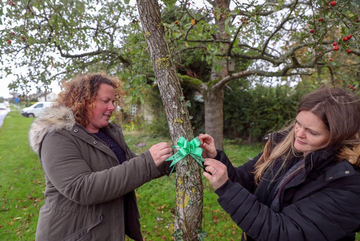 Harry Dunn's Auntie Katie Grant (right) and Nicola Watson tie a Green Ribbons which are being made be members of the village of Charlton, Oxfordshire in memory of 19-year-old Harry Dunn who died while out riding his Green motorcycle near RAF Croughton.