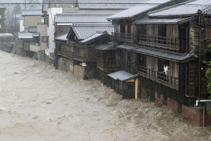 Men watch the swollen Isuzu River due to heavy rain caused by Typhoon Hagibis in Ise, central Japan, in this photo taken by Kyodo October 12.
