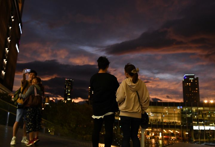 People look at clouds during sunset near Osaka Station, as typhoon 'Hagibis' approaches Japan, in Osaka, Japan October 12, 2019. REUTERS/Annegret Hilse