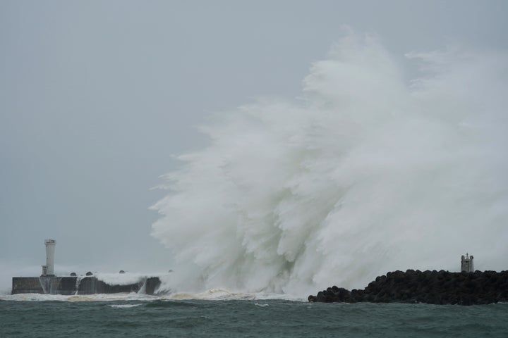 Surging waves hit against the breakwater and a lighthouse as Typhoon Hagibis approaches at a port in town of Kiho, Mie prefec