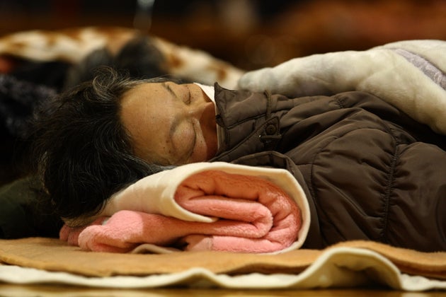 Une femme dort dans un refuge à Tokyo, ce 12