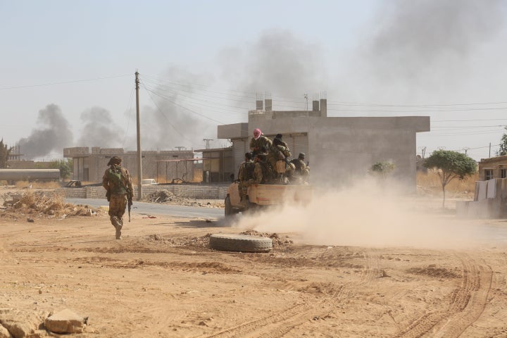 In this Saturday, Oct. 12, 2019 photo, Turkey-backed Syrian fighters enter Ras al-Ayn, Syria. (AP Photo)