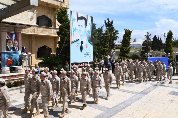 Ρώσοι στρατιώτες μπροστά από αφίσα του Μπασάρ αλ Άσαντ, Συρία, Μάιος 2019. 