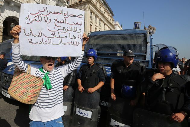 Algerian protesters face riot police at a demonstration near the parliament building in Algiers on October...