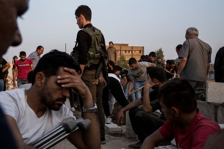 Syrians bury Syrian Democratic Forces fighters killed fighting Turkish advance in the Syrian town of Qamishli, Saturday, Oct. 12, 2019. (AP Photo/Baderkhan Ahmad)