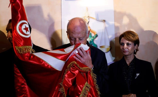 Tunisian presidential candidate Kais Saied and his wife Ichraf Chebil react after exit poll results were...