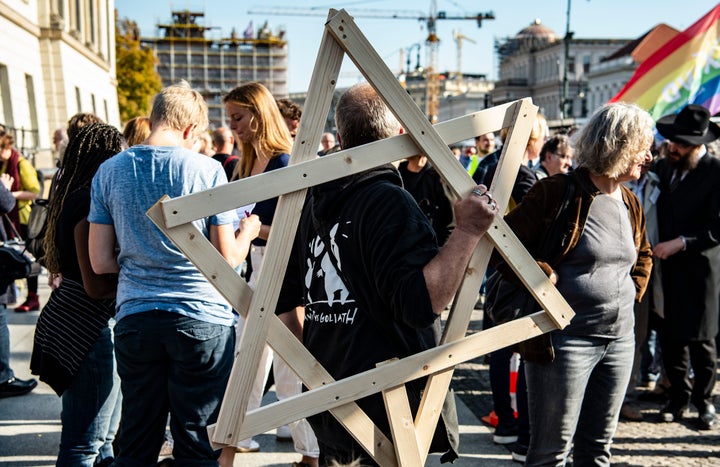 A demonstrator with a large wooden star of David over his shoulder participates in a protest against anti-Semitism. 