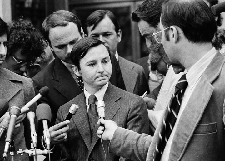 Donald Segretti, a political saboteur financed with Nixon campaign funds, is surrounded by newsmen as he listens to questions