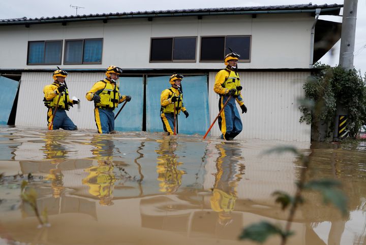 Police search a flooded area Monday in the aftermath of Typhoon Hagibis, which caused severe floods at the Chikuma River in Nagano Prefecture, Japan.