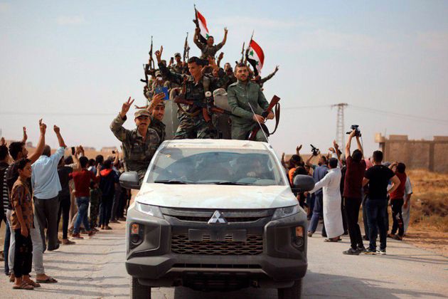 Φωτογραφία που διένειμε το κρατικό πρακτορείο ειδήσεων της Συρίας, Sana με πολίτες να καλωσορίζουν τον στρατό του Άσαντ στη ΒΑ Συρία. 