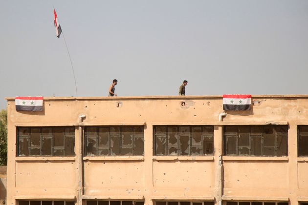 Δυνάμει του Άσαντ υψώνουν συριακές σημαίες σε κτήρια του χωριού Γκεμπες, δυτικά της πόλης Ταλ Ταμρ. 