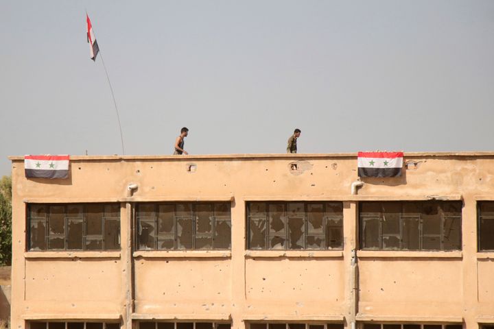 Δυνάμει του Άσαντ υψώνουν συριακές σημαίες σε κτήρια του χωριού Γκεμπες, δυτικά της πόλης Ταλ Ταμρ. 