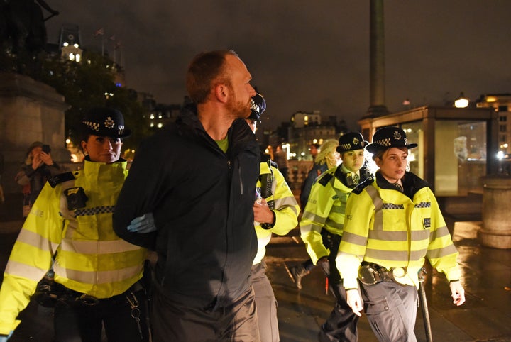 Police remove an Extinction Rebellion protester from Trafalgar Square in central London.