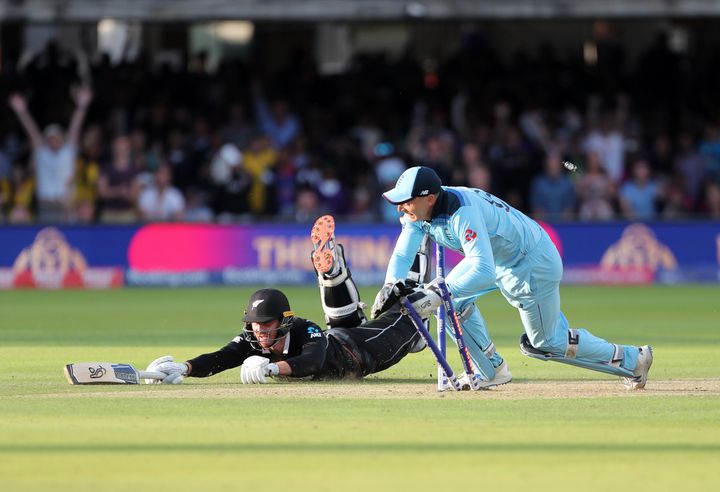 England's Jos Buttler runs out New Zealand's Martin Guptill during the Super Over in the Cricket World Cup final match between England and New Zealand, July 14, 2019. 