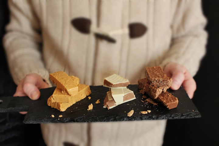 Man offering three types of Turron on slate