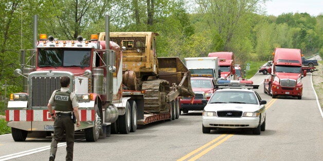 Police lead a convoy of seized heavy equipment following a police raid at the Kanesatake territory in Oka, Que., on May 19, 2009 in Montreal.