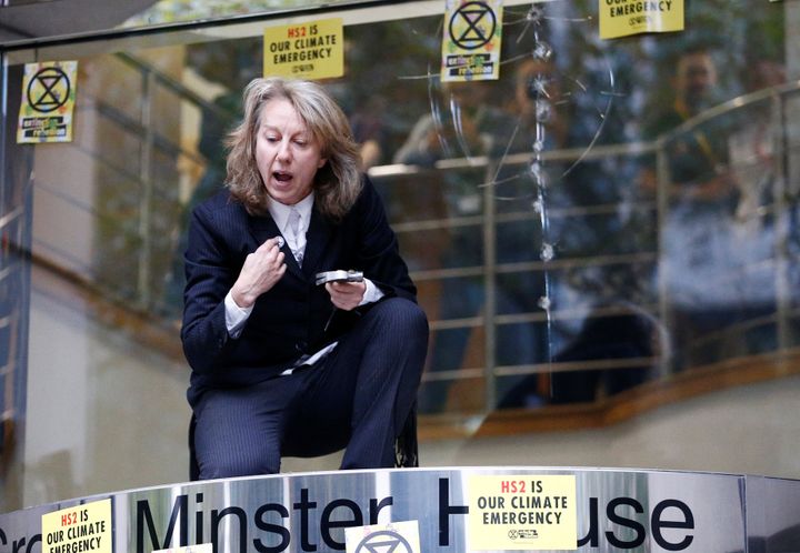 Co-founder of the Extinction Rebellion group, Gail Bradbrook, speaks as she kneels atop the doorway into the Department of Transport