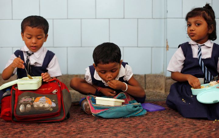 Schoolgirls eat their free mid-day meal, distributed by a government-run primary school, in New Delhi July 5, 2013. 