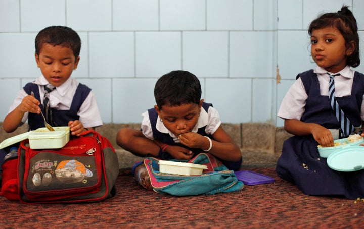 Schoolgirls eat their free mid-day meal, distributed by a government-run primary school, in New Delhi July 5, 2013. 