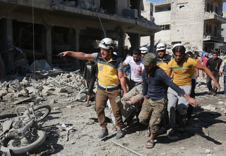 People carry wounded people to hospitals after Russian warplane carried out airstrikes on a marketplace in Maarat al-Numan district of Idlib, Syria on July 22.