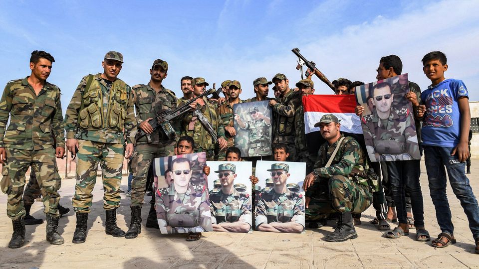 Στρατιώτες του στρατού του Μπασάρ αλ Άσαντ με σημαίες της Συρίας και φωτογραφίες του προέδρου της χώρας σε περίχωρα της Μανμπίτζ, 15 Οκτωβρίου 2019. 