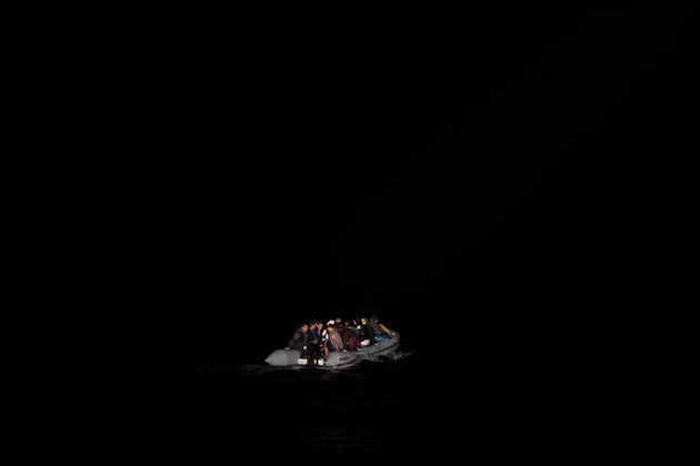 Στελέχη του ελληνικού λιμενικού φωτίζουν με φακούς 23 πρόσφυγες και μετανάστες από τη Συρία, το Ιράκ, την Παλαιστίνη και το Ιράν, που είχαν ξεκινήσει από κοντινή Τουρκία με προορισμό τη Σάμο.