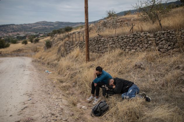 Εξαντλημένοι άνδρες κοιμούνται κοντά στην πόλη του Μανταμάδου, μετά την άφιξή τους με άλλους μετανάστες και πρόσφυγες με πλαστική βάρκα από την Τουρκία στη Λέσβο.