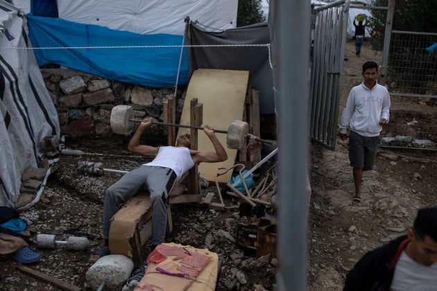 Ενας άνδρας από την Καμπούλ του Αφγανιστάν γυμνάζεται με αυτοσχέδια βάρη στον προσφυγικό καταυλισμό της Μόριας.