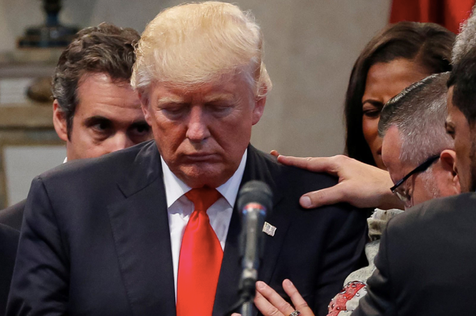 Trump’s personal attorney at the time, Michael Cohen, keeps watch as supporters lay hands on the then-presidential nominee. “