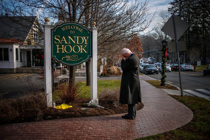 A mourner grieves at the entrance to Sandy Hook village in Newtown, Connecticut, on December 15, 2012.