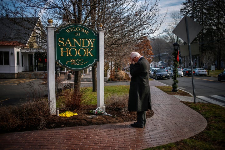 A mourner grieves at the entrance to Sandy Hook village in Newtown, Connecticut, on December 15, 2012.