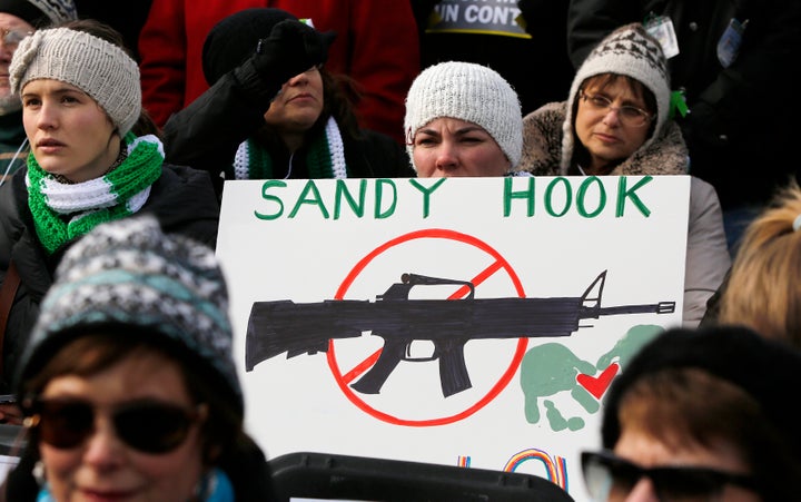 People participating in the March on Washington for Gun Control in 2013 hold signs memorializing those killed at Sandy Hook Elementary School in 2012.