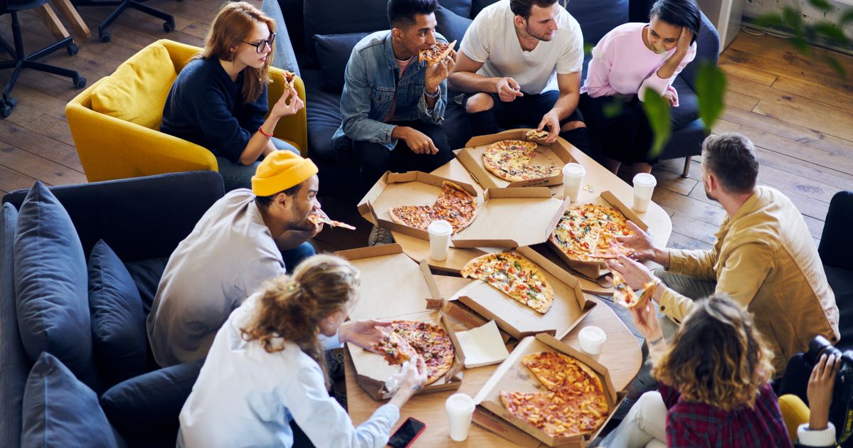 Где едят люди в доме. Пицца в офисе. Люди в пиццерии. Люди едят в пиццерии. Едят пиццу в офисе.