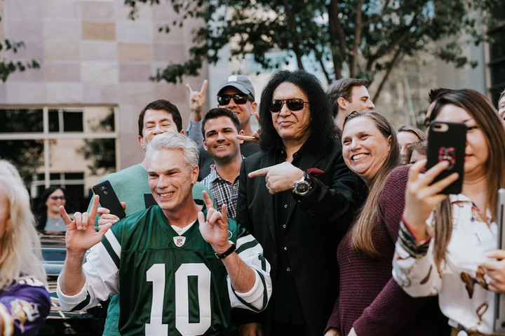 Intuit CEO Brad Smith flashes the “rock on” hand sign next to Kiss’ Gene Simmons during Smith’s 2018 farewell tour at TurboTa