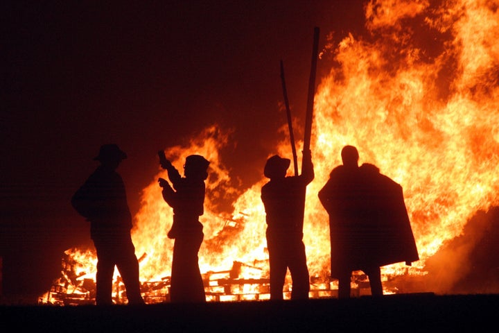 Revellers stand near the fires during the first of the Bonfire Night celebrations on Sept. 25, 2004 in Burgess Hill, England. Bonfire Night is related to the ancient festival of Samhain, the Celtic New Year otherwise known as Halloween. 