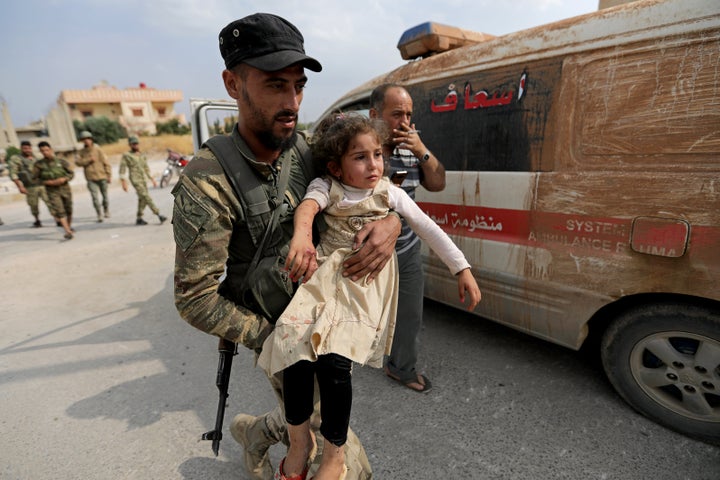 A wounded girl is carried by a Turkey-backed Syrian rebel fighter in the town of Tal Abyad, Syria, on Sunday.