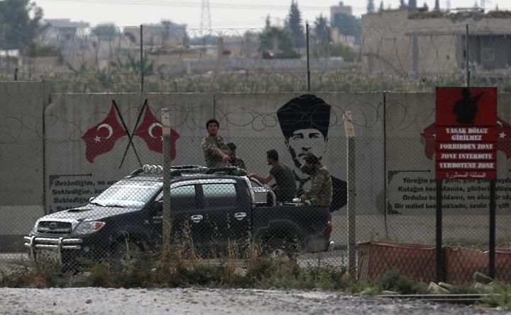 Turkey-backed Syrian rebel fighters return from the Syrian border town of Tal Abyad, as they are pictured on the Turkish-Syri