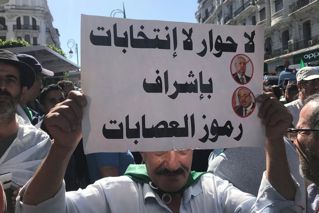 A demonstrator carries a banner during a protest demanding the army quit politics, a purge of the ruling...