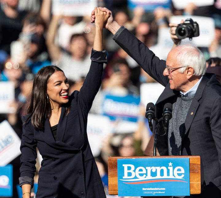 Democratic presidential candidate Sen. Bernie Sanders (I-Vt.) joins hands with Rep. Alexandria Ocasio-Cortez (D-N.Y.) during a campaign rally on Saturday in New York.