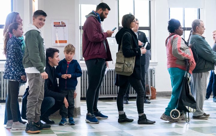Justin Trudeau lines up to vote with his family in Montreal on Oct. 21, 2019. 