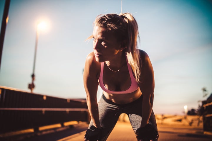 Exhausted woman after fitness workout, doing freeletics outdoor in the city.