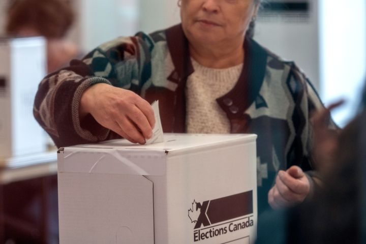 A woman votes at a polling station in Toronto for the federal election, Oct. 21, 2019. 