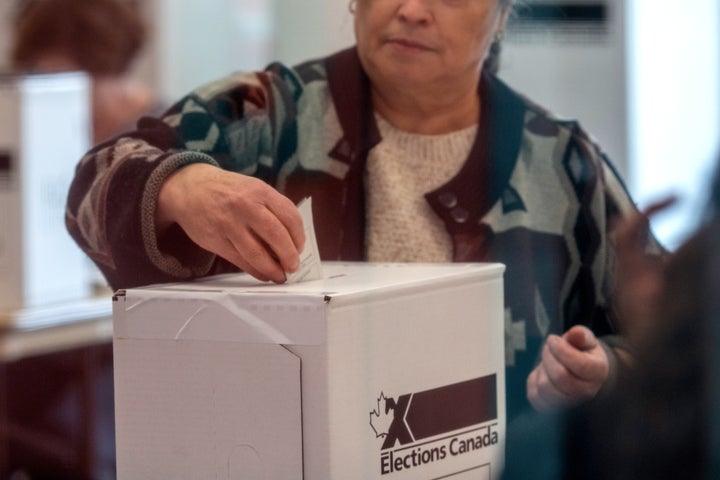 A woman votes at a polling station in Toronto for the federal election, Oct. 21, 2019. 