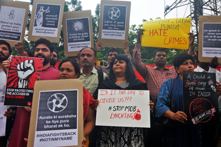 Indians hold placards and shout slogans during a protest against mob attacks in Ahmedabad, July 23, 2018.