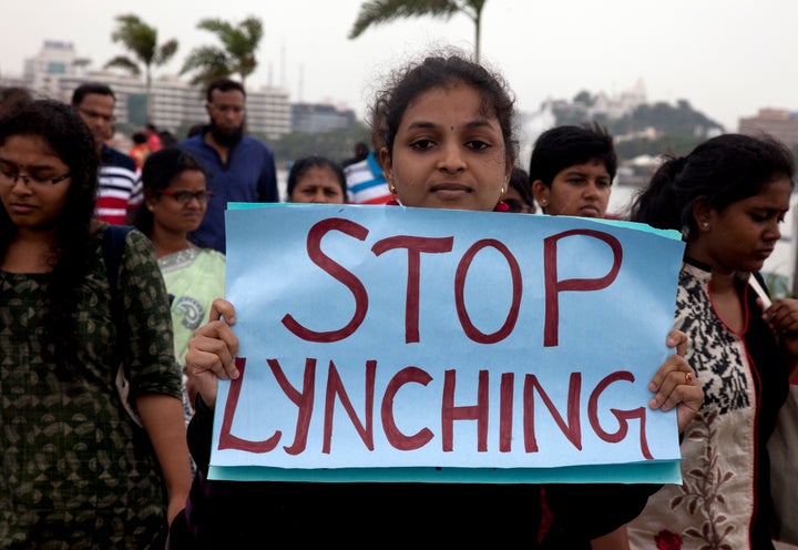 A woman holds a placard and walks to join a protest against a spate of violent attacks across the country, in Hyderabad, June 28, 2017.