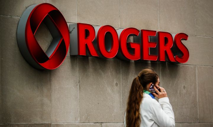 A woman speaks on her cell phone in front of a Rogers sign at the company's annual general meeting for shareholders in Toronto, April 22, 2014.