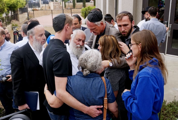 Rabbi Yisroel Goldstein (center) hugs his congregants after a press conference outside the Chabad of Poway Synagogue on April 28, 2019. The rabbi was wounded in a shooting at his California synagogue the previous day.