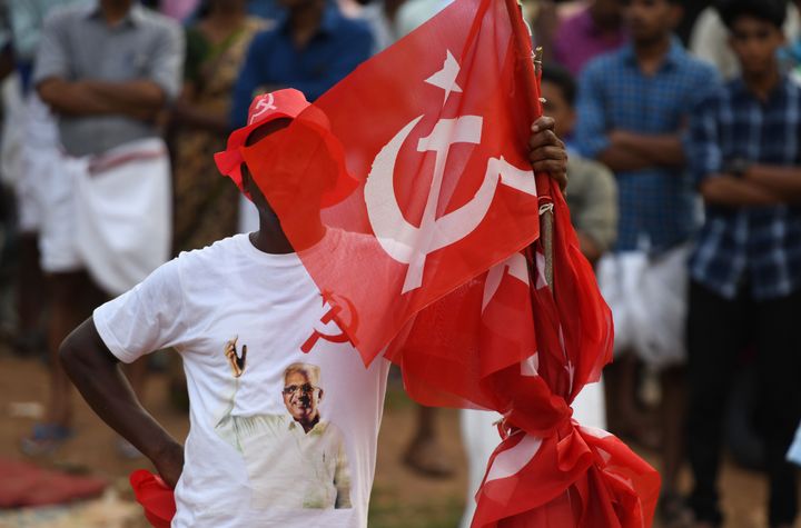 A supporter of the Communist Party of India (Marxist) carries a party flag at an election campaign rally in this file photo. 