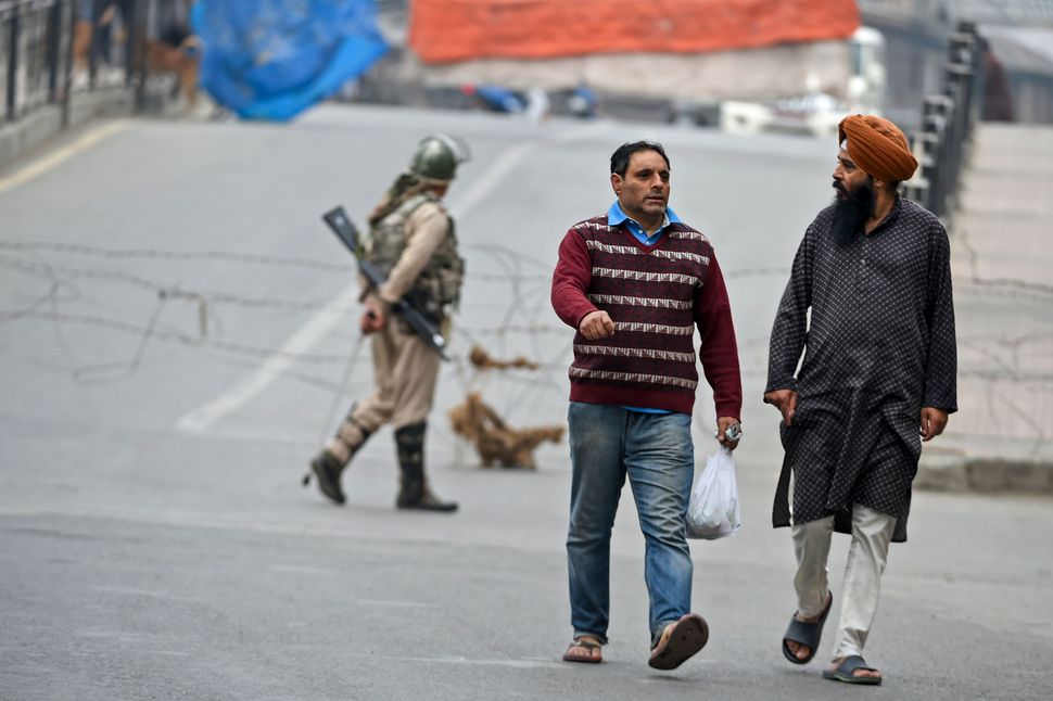 Kashmiri men walk past during a lockdown in Srinagar on 28 September, 2019. 