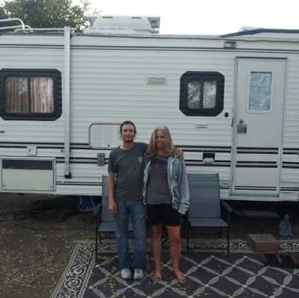 Kim Coulon and her boyfriend stand in front of the RV that they've been living in since the Camp fire and that is currently parked in Durham, California.
